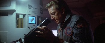 Movie still from “2010: The Year We Make Contact” (1984), directed by Peter Hyams – A man holding a microphone in his hands; Close Up shot, Low angle