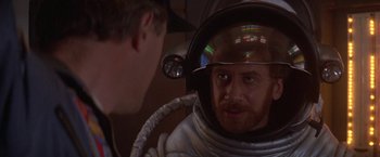 Movie still from “2010: The Year We Make Contact” (1984), directed by Peter Hyams – A man wearing a space suit and a helmet; Close Up shot, Over the shoulder angle
