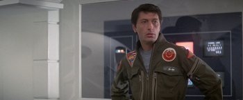 Movie still from “2010: The Year We Make Contact” (1984), directed by Peter Hyams – A man in a military jacket standing in front of a mirror; Close Up shot, Low angle