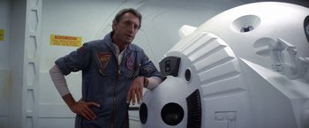 Movie still from “2010: The Year We Make Contact” (1984), directed by Peter Hyams – A man standing in front of a white object; Medium shot, Low angle