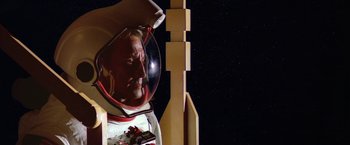 Movie still from “2010: The Year We Make Contact” (1984), directed by Peter Hyams – An image of a man in a spacesuit in front of a space station; Close Up shot, Low angle