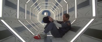 Movie still from “2010: The Year We Make Contact” (1984), directed by Peter Hyams – A man sitting on the floor of a room; Medium shot, Low angle