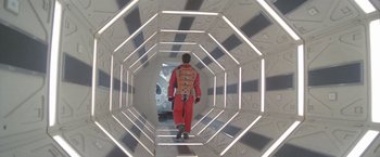 Movie still from “2010: The Year We Make Contact” (1984), directed by Peter Hyams – A man in a space suit walking through a tunnel; Wide shot, Overhead angle