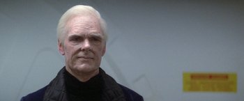 Movie still from “2010: The Year We Make Contact” (1984), directed by Peter Hyams – An older man with white hair wearing a black shirt; Close Up shot, Over the shoulder angle