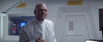 Movie still from “2010: The Year We Make Contact” (1984), directed by Peter Hyams – An old man in a white shirt is looking at the camera; Close Up shot, Over the shoulder angle