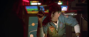 Movie still from “2010: The Year We Make Contact” (1984), directed by Peter Hyams – A man in a space suit is holding an object in his hand; Medium shot, Low angle