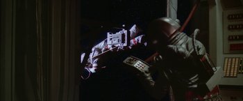 Movie still from “2010: The Year We Make Contact” (1984), directed by Peter Hyams – A person in a space suit holding a remote control; Wide shot, Low angle