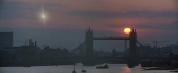 Movie still from “2010: The Year We Make Contact” (1984), directed by Peter Hyams – The sun is setting over a river with boats in it; Extreme Wide shot, Low angle