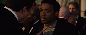 Movie still from “2012” (2009), directed by Roland Emmerich – A man that is talking to someone; Close Up shot, Over the shoulder angle