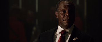 Movie still from “2012” (2009), directed by Roland Emmerich – A man in a suit and red tie looking to his left; Close Up shot, Low angle