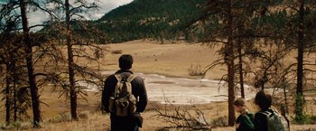 Movie still from “2012” (2009), directed by Roland Emmerich – A man with a backpack looking out at a valley; Extreme Wide shot, High angle