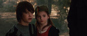Movie still from “2012” (2009), directed by Roland Emmerich – Two children standing next to each other in the woods; Close Up shot, Low angle