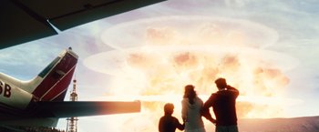 Movie still from “2012” (2009), directed by Roland Emmerich – A group of people standing in front of an explosion; Wide shot, Over the shoulder angle