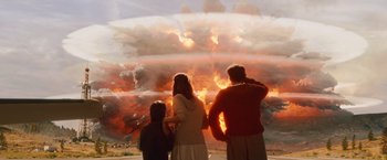 Movie still from “2012” (2009), directed by Roland Emmerich – Three people looking at an explosion in the sky; Wide shot, Over the shoulder angle