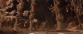 Movie still from “2012” (2009), directed by Roland Emmerich – A man standing on the side of a road in front of a large amount of smoke; Extreme Wide shot, High angle