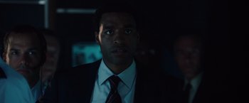 Movie still from “2012” (2009), directed by Roland Emmerich – A person wearing a suit and tie; Close Up shot, Low angle