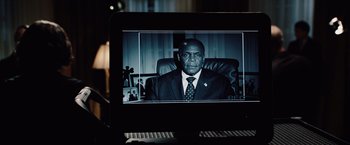 Movie still from “2012” (2009), directed by Roland Emmerich – A man sitting in a chair in front of a computer screen; Close Up shot, Over the shoulder angle