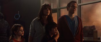 Movie still from “2012” (2009), directed by Roland Emmerich – A group of people standing next to each other in front of a window; Medium shot, Low angle