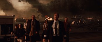 Movie still from “2012” (2009), directed by Roland Emmerich – A group of people walking across a runway; Wide shot, Low angle