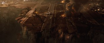 Movie still from “2012” (2009), directed by Roland Emmerich – An aerial view of an airport with a lot of smoke; Extreme Wide shot, Overhead angle