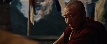 An older man wearing a red and yellow shirt