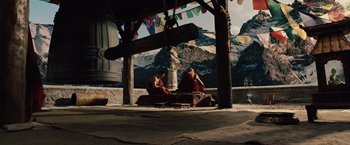 Movie still from “2012” (2009), directed by Roland Emmerich – Two monks sitting under an awning in front of mountains; Wide shot, High angle