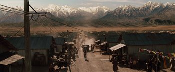 Movie still from “2012” (2009), directed by Roland Emmerich – An image of a man riding a bike down the street; Extreme Wide shot, High angle