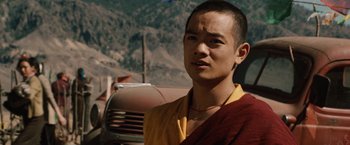 Movie still from “2012” (2009), directed by Roland Emmerich – A man in a yellow and red shirt standing in front of a truck; Close Up shot, Over the shoulder angle