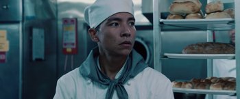 Movie still from “2012” (2009), directed by Roland Emmerich – A man in a chef's outfit in a commercial kitchen; Close Up shot, Low angle