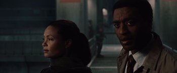 Movie still from “2012” (2009), directed by Roland Emmerich – A man and a woman standing next to each other; Close Up shot, Over the shoulder angle