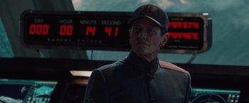 Movie still from “2012” (2009), directed by Roland Emmerich – An older man wearing a uniform and a hat; Close Up shot, Over the shoulder angle