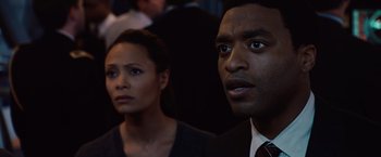 Movie still from “2012” (2009), directed by Roland Emmerich – A man and a woman are looking at the camera; Close Up shot, Over the shoulder angle