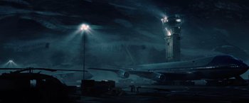 Movie still from “2012” (2009), directed by Roland Emmerich – An airplane sitting on a runway at night; Extreme Wide shot, Low angle