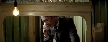 Movie still from “2046” (2004), directed by Kar-Wai Wong – A man talking on a phone while holding a banana; Medium shot, High angle