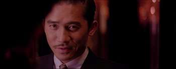 Movie still from “2046” (2004), directed by Kar-Wai Wong – A person wearing a suit and tie; Close Up shot, Low angle