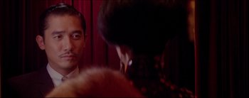 Movie still from “2046” (2004), directed by Kar-Wai Wong – A man and a woman looking at each other in front of a mirror; Close Up shot, Over the shoulder angle