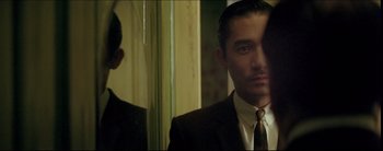 Movie still from “2046” (2004), directed by Kar-Wai Wong – A man wearing a suit and tie in front of a mirror; Close Up shot, Over the shoulder angle