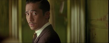 Movie still from “2046” (2004), directed by Kar-Wai Wong – A person wearing a suit and tie; Close Up shot, Low angle