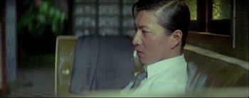 Movie still from “2046” (2004), directed by Kar-Wai Wong – A person wearing a suit and tie; Close Up shot, Low angle