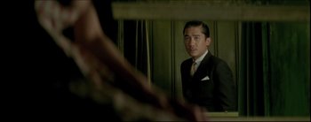 Movie still from “2046” (2004), directed by Kar-Wai Wong – A man in a suit looking at himself in a mirror; Medium shot, Over the shoulder angle