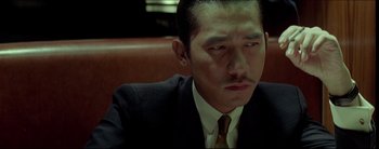 Movie still from “2046” (2004), directed by Kar-Wai Wong – A person wearing a suit and tie; Close Up shot, High angle
