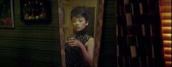 Movie still from “2046” (2004), directed by Kar-Wai Wong – A woman is taking a picture of herself in the mirror; Medium shot, Low angle