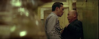 Movie still from “2046” (2004), directed by Kar-Wai Wong – A man and a woman standing next to each other in a room; Medium shot, Over the shoulder angle