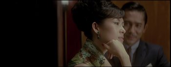 Movie still from “2046” (2004), directed by Kar-Wai Wong – A young woman wearing an oriental style dress and earrings; Close Up shot, Over the shoulder angle