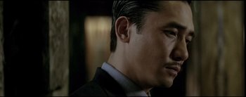 Movie still from “2046” (2004), directed by Kar-Wai Wong – A person wearing a suit and tie; Close Up shot, Low angle
