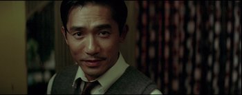 Movie still from “2046” (2004), directed by Kar-Wai Wong – A person wearing a suit and tie; Close Up shot, Low angle