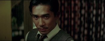 Movie still from “2046” (2004), directed by Kar-Wai Wong – A person wearing a suit and tie; Close Up shot, Low angle
