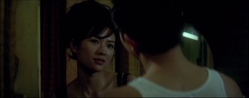 Movie still from “2046” (2004), directed by Kar-Wai Wong – A woman looking at her reflection in a mirror; Close Up shot, Over the shoulder angle