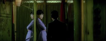 Movie still from “2046” (2004), directed by Kar-Wai Wong – A man and a woman standing next to each other in a doorway; Medium shot, Over the shoulder angle