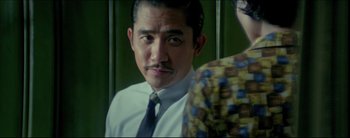 Movie still from “2046” (2004), directed by Kar-Wai Wong – A person wearing a suit and a tie; Medium shot, Over the shoulder angle